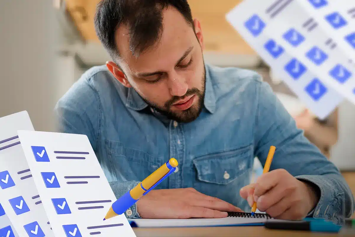 Homem Concentrado Fazendo Anotações em Notebook Homem olhando para anotações em notebook com listas de tarefas ao redor