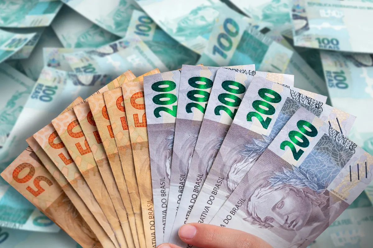 Impacto do salário mínimo na renda em 2026. Cédulas de real de diferentes valores representando o reajuste do salário mínimo em 2026.