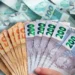 Dinheiro em notas de Real (R$ 50, R$ 100, R$ 200) simbolizando o Piso Salarial Nacional para os funcionários técnico-administrativos e operacionais da educação.