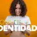 Mulher segura a Nova Carteira de Identidade Nacional (CIN), destacando o documento com QR Code e CPF, foco da matéria sobre a lista de documentos para a emissão.