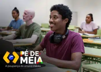 Homem jovem sorridente segurando um cofrinho e notas de dinheiro, com o logotipo do programa Pé-de-Meia ao fundo, representando o recebimento do benefício estudantil.