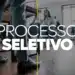 Pessoas participando de processo seletivo em ambiente profissional com homem em primeiro plano