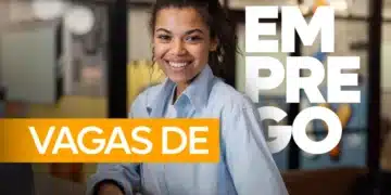 Mulher jovem sorridente de camisa azul sentada em um escritório, com as palavras "Vagas de Emprego" sobrepostas em faixas amarela e branca.