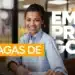 Mulher jovem sorridente de camisa azul sentada em um escritório, com as palavras "Vagas de Emprego" sobrepostas em faixas amarela e branca.