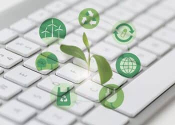 Teclado branco com planta verde crescendo e ícones circulares de sustentabilidade