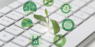 Teclado branco com planta verde crescendo e ícones circulares de sustentabilidade