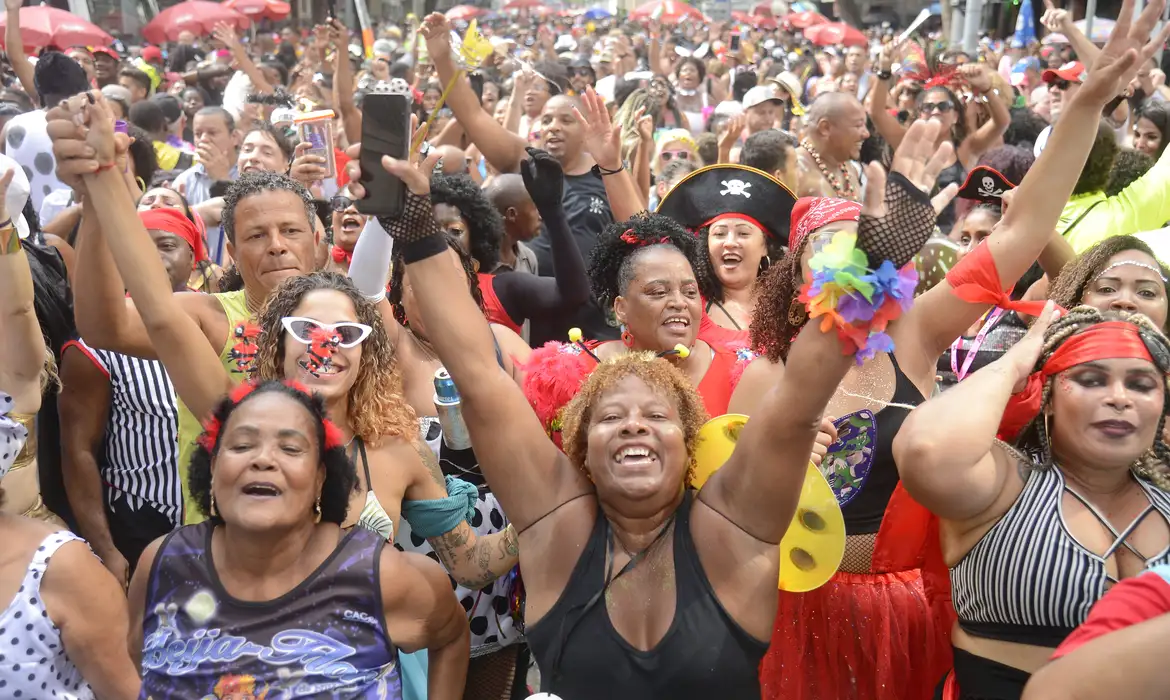 Carnaval com multidão animada e colorida Grupo diversificado de pessoas felizes celebrando carnaval com fantasias e adereços coloridos em festa ao ar livre
