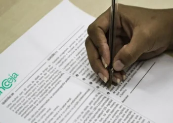 Pessoa preenchendo prova do Encceja, relacionada à divulgação do resultado de 2025.
