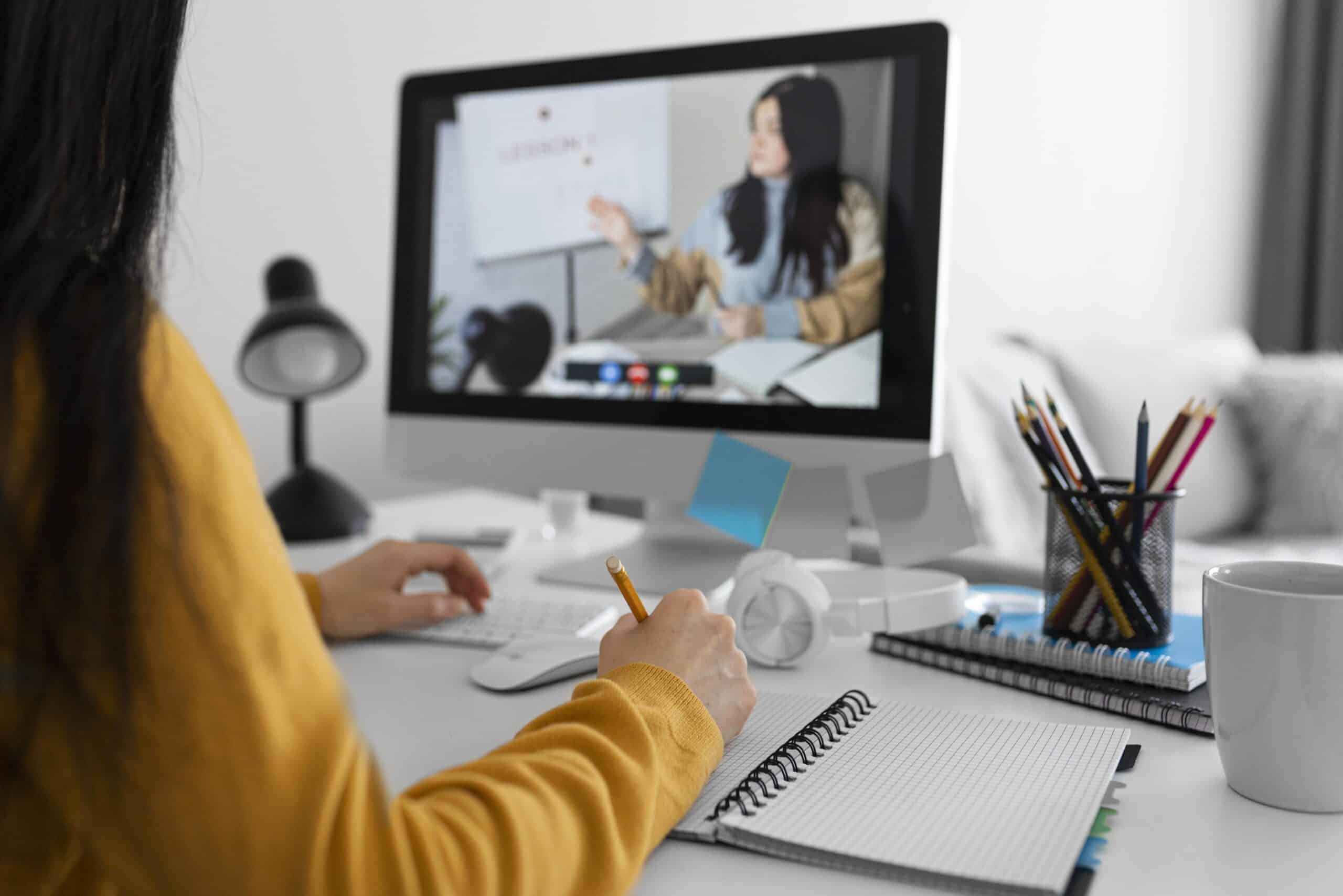 Jovem fazendo um curso online em um computador. A cena representa a qualificação em novas tecnologias como IA e conteúdo digital, essenciais para aumentar a empregabilidade e a renda.