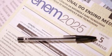Caderno de prova Enem 2025 amarelo com caneta esferográfica sobre folha de rascunho