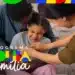 Pai e mãe abraçando e brincando com uma criança sorridente em um momento de carinho familiar, com o logotipo colorido do Programa Bolsa Família sobreposto no canto inferior esquerdo.