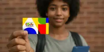 Adolescente segura cartão colorido do Programa Bolsa Família