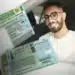 Homem de óculos sentado no banco do motorista segurando carteira nacional de habilitação