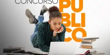 Jovem estudando em laptop com vários livros ao redor para concurso público