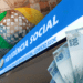 Fachada do INSS com várias cédulas de reais, simbolizando atualização dos valores em 2026.