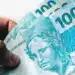 Notas de R$100 do Brasil representando aumento no salário mínimo em 2026.