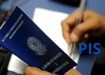 Pessoa preenchendo a carteira de trabalho para obter o número do PIS pela primeira vez.
