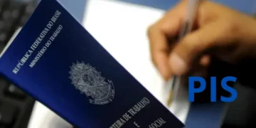 Pessoa preenchendo a carteira de trabalho para obter o número do PIS pela primeira vez.