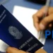 Pessoa preenchendo a carteira de trabalho para obter o número do PIS pela primeira vez.