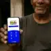 Homem segurando celular com aplicativo do Bolsa Família aberto em 2026