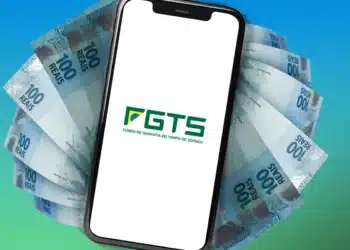 Celular com aplicativo do FGTS exibindo logo e notas de 100 reais em fundo colorido