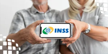 Casal segurando celular com logo do INSS, tema INSS fora do ar