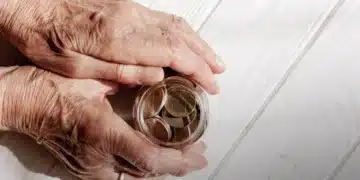 Mãos idosas segurando pote de moedas, simbolizando reajuste do teto do INSS