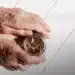 Mãos idosas segurando pote de moedas, simbolizando reajuste do teto do INSS