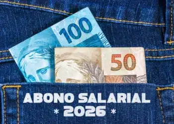 Nota de R$ 100 e R$ 50 visíveis no bolso de jeans, representando o Abono Salarial de 2026