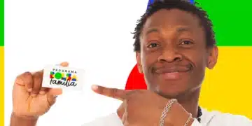 Homem sorrindo aponta para cartão do Bolsa Família sobre fundo colorido