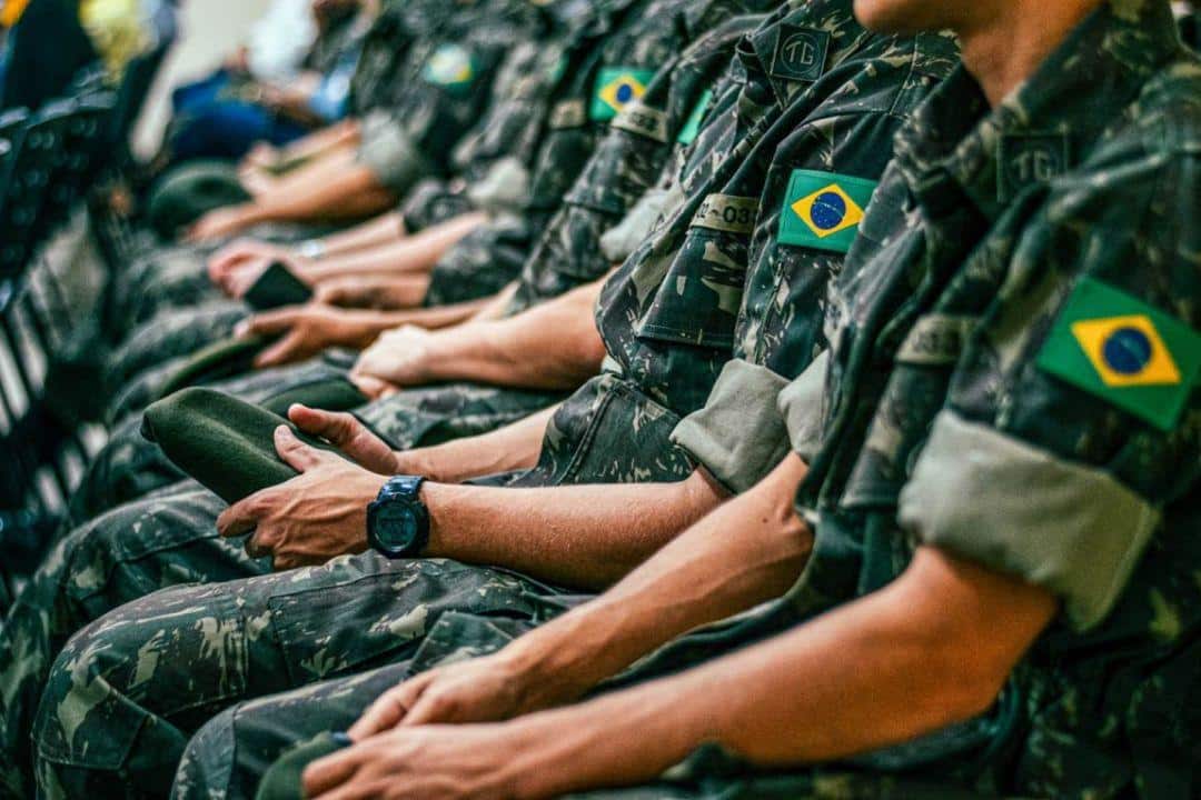 Jovens militares em formação, aguardando instruções durante o alistamento.