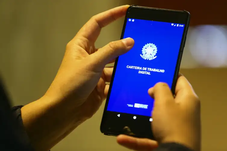 Carteira de Trabalho Digital: Praticidade e Modernidade Mãos utilizando aplicativo Carteira de Trabalho Digital em smartphone