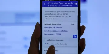 Pessoa acessando aplicativo no celular para verificar descontos de entidades associativas no INSS.