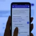 Pessoa acessando aplicativo no celular para verificar descontos de entidades associativas no INSS.
