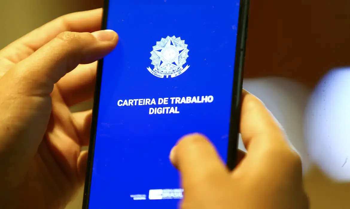 Carteira de Trabalho Digital pelo celular Pessoa segurando smartphone mostrando tela da Carteira de Trabalho Digital