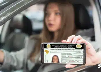 Mulher exibindo a versão digital da CNH no celular enquanto está dentro de um carro.