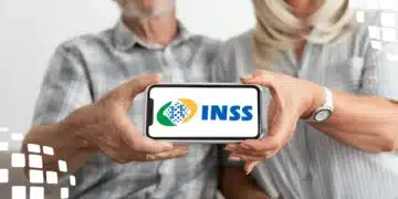 Casal de idosos segurando um smartphone com o logo do INSS na tela.
