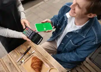 Pagamento via Pix sendo realizado em um ponto de venda, com smartphone exibindo a interface do Pix.