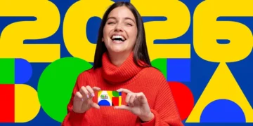 Mulher sorrindo com cartão do Bolsa Família, destacando os pagamentos de 2026 e os grupos prioritários do programa.
