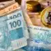 Notas de Real e moeda do Brasil, representando o tema dos benefícios do INSS em 2026, como Salário-Família, BPC, Auxílio-Reclusão e outros.