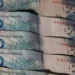 Cédulas de 100 reais do Brasil empilhadas, com detalhes visíveis das cores e elementos de segurança.