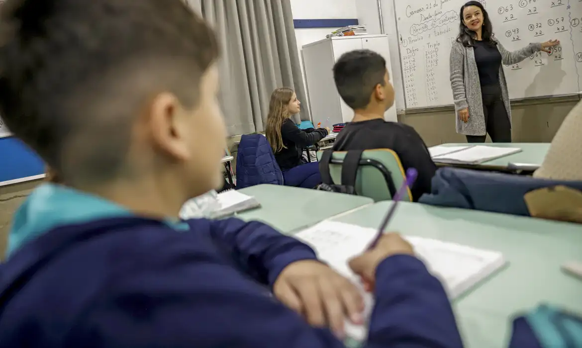 Aula de matemática em sala de aula no Brasil em 2026 Professora ensina matemática no quadro para alunos atentos em sala de aula