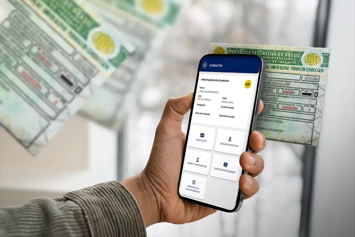 Consulta digital da CNH com aplicativo no celular Pessoa segurando celular com aplicativo mostrando dados da CNH e carteira de motorista ao fundo