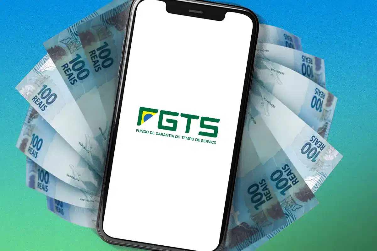 FGTS Digital 2026: acesso fácil pelo celular Celular exibindo logo do FGTS à frente de notas de 100 reais