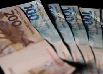 Notas de 100 e 200 reais do Brasil com fundo escuro, representando valores do programa Pé-de-Meia em 2026.