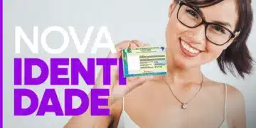 Jovem segurando carteira de identidade ao lado do rosto e sorrindo para a câmera.