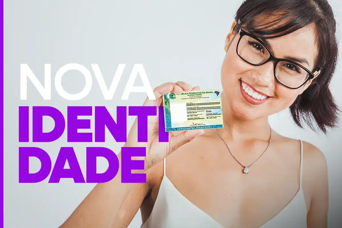 Nova identidade. Jovem segurando carteira de identidade ao lado do rosto e sorrindo para a câmera.