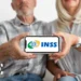 Mãos de casal segurando celular com logotipo do INSS na tela, destaque para acessibilidade digital