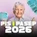 Mulher idosa segura várias notas de R$ 100 em fundo rosa, destacando PIS PASEP 2026