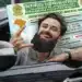 Homem sorrindo dentro do carro comemora ao segurar documento da CNH após conseguir vaga gratuita